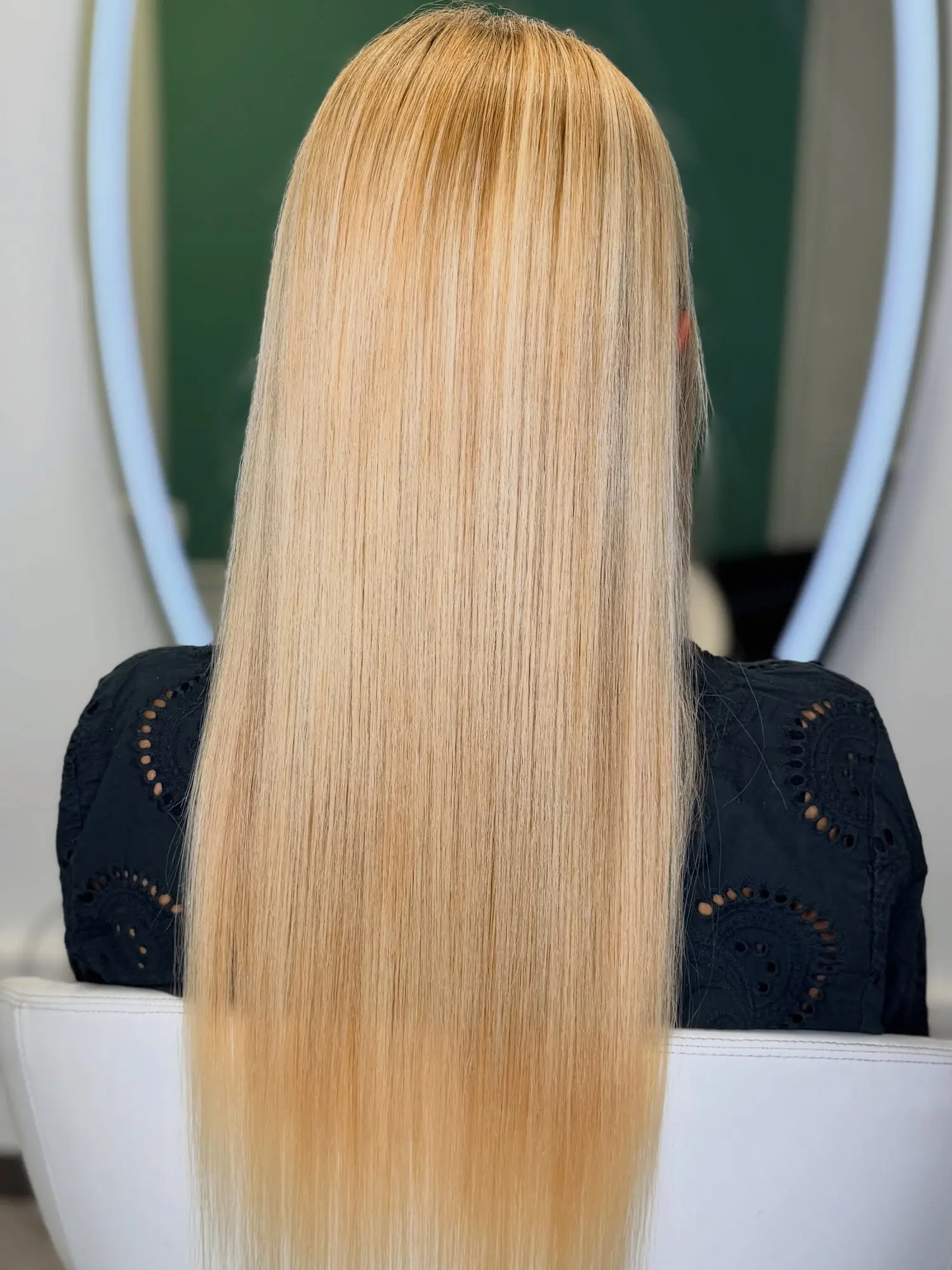 Capelli biondi lunghi e lisci dopo la nanoplastia, sulla poltrona del salone