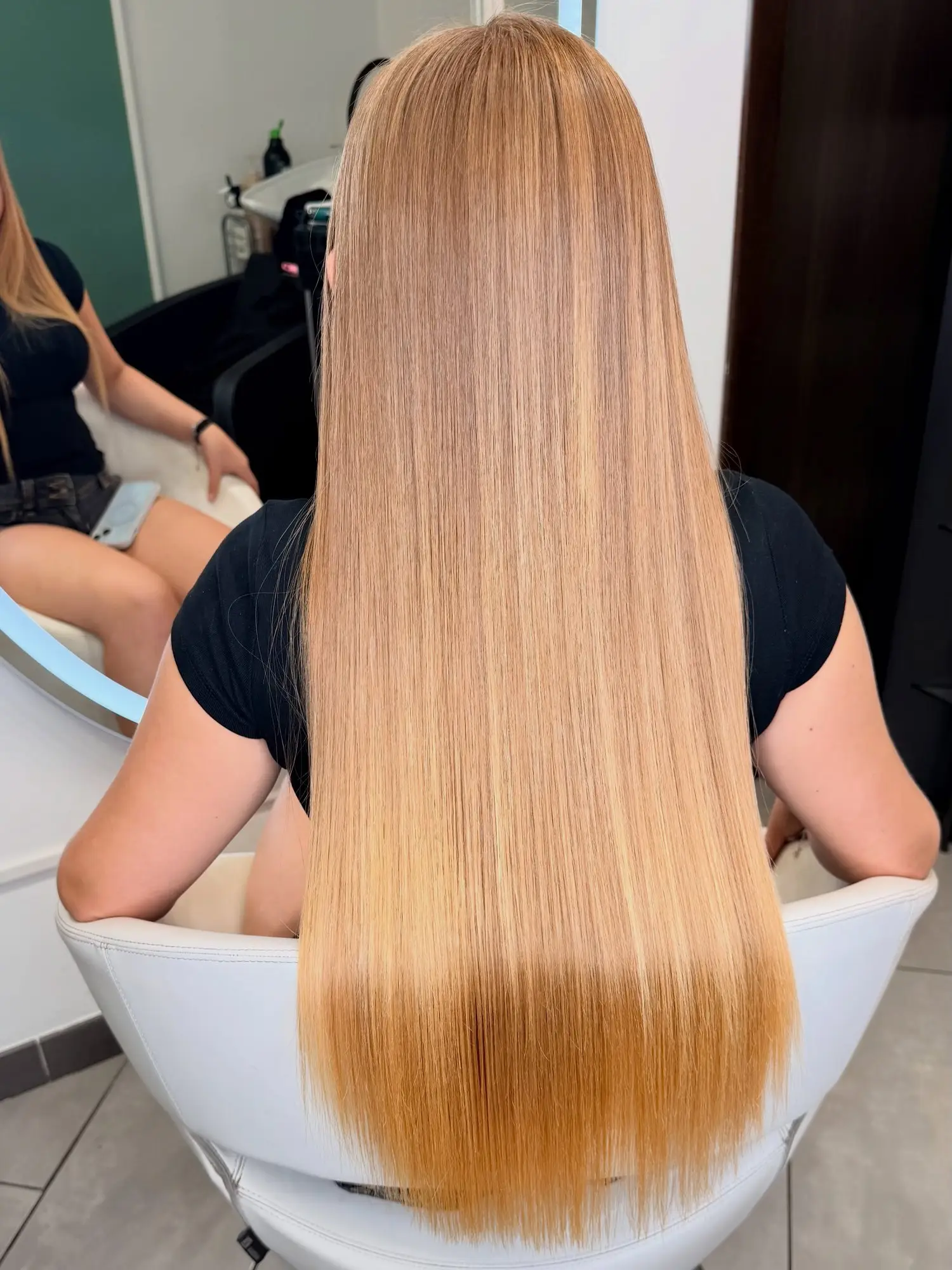 Capelli biondo miele lunghi, lisci, sulla poltrona bianca